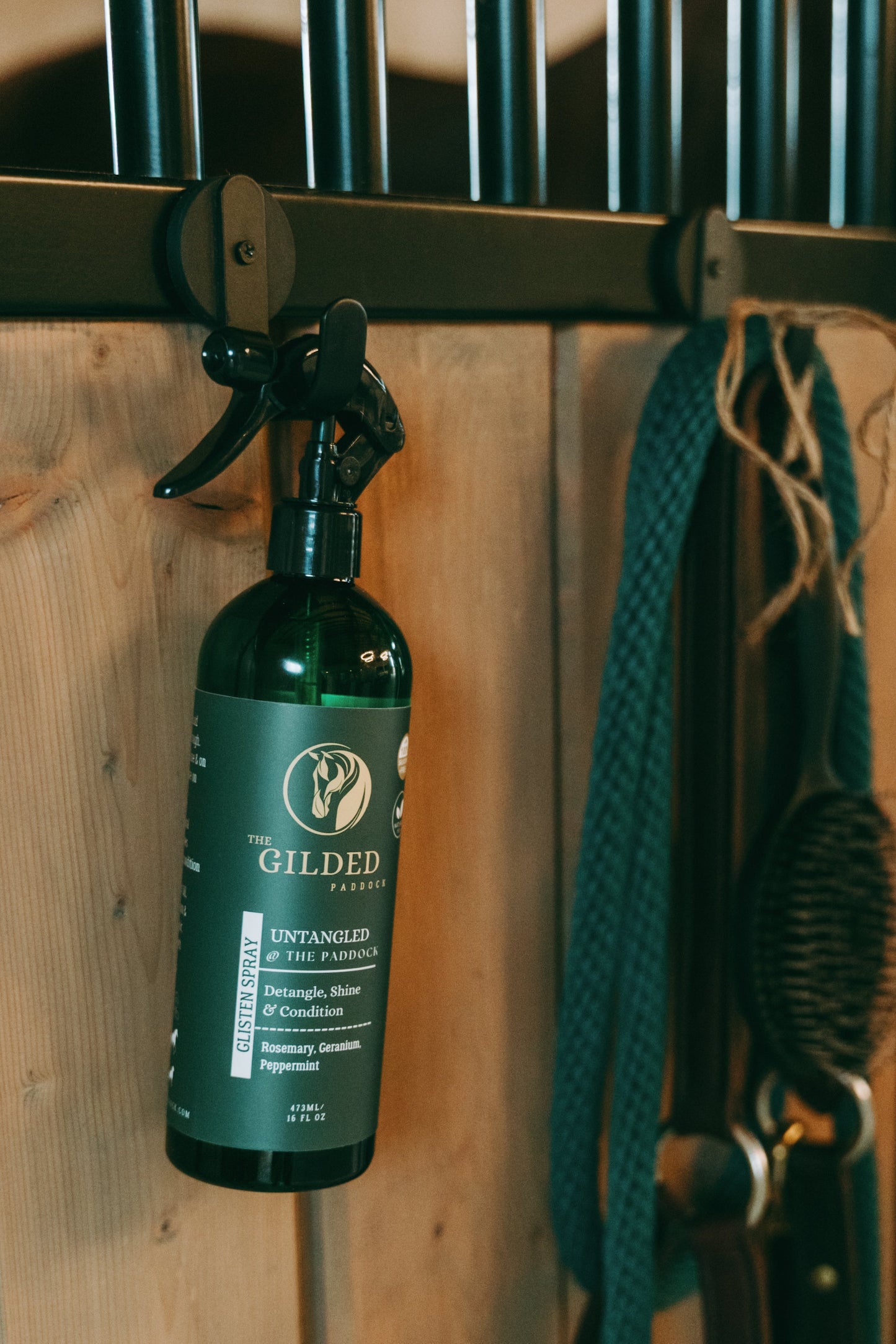 Green bottle with a label hanging on a wooden stable door.
